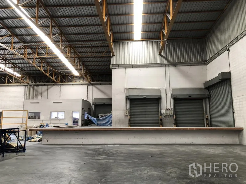 Warehouse for rent in Phra Nakhon Si Ayutthaya - Three dock-high roller shutters and a raised loading platform inside the warehouse.