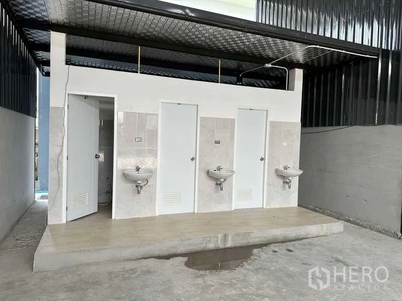 คลังสินค้า ให้เช่าในKhlong Sam Wa, Bangkok - ชุดห้องน้ำแยกภายในโกดัง มีประตูสีขาวและอ่างล้างมือ