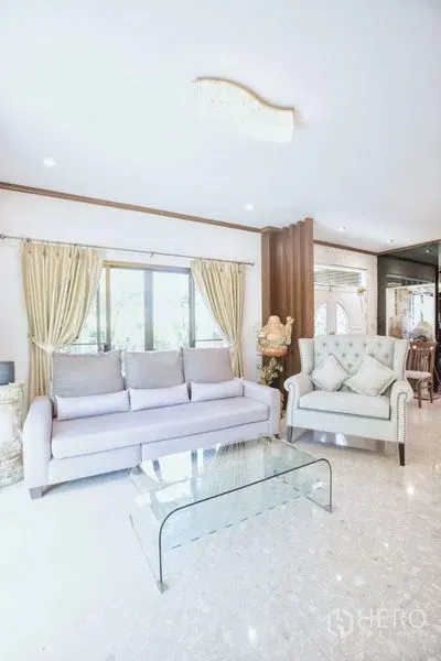 บ้าน ขายในLat Krabang, Bangkok - ห้องนั่งเล่นสว่างด้วยหน้าต่างบานใหญ่ โซฟา อาร์มแชร์ และโต๊ะกลางกระจก พื้นเงางาม