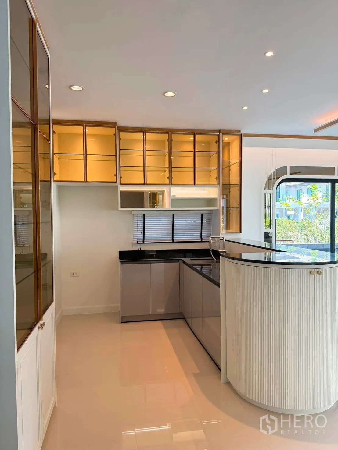 Detached House for rent or sale in Prawet, Bangkok - Open pantry with curved breakfast bar and glass-front cabinets.