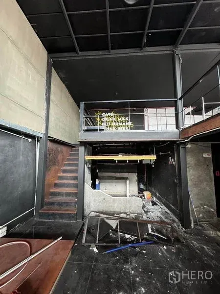 店屋 出租在Phaya Thai, Bangkok - 首层挑高空间带钢结构夹层、楼梯与旧吧台，适合改造。