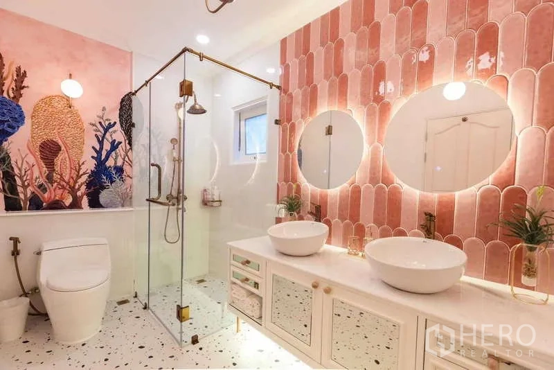 联排别墅 出租在Lat Phrao, Bangkok - 浴室采用粉色鱼鳞砖，玻璃淋浴间与双圆盆及水磨石地面。