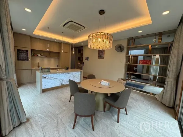 Detached House for rent in Prawet, Bangkok - Dining space with round table, crystal chandelier and backlit marble island.