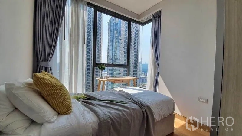 公寓 出租在Khlong Toei, Bangkok - 采光充足的卧室，落地窗与学习桌面向城市景观。