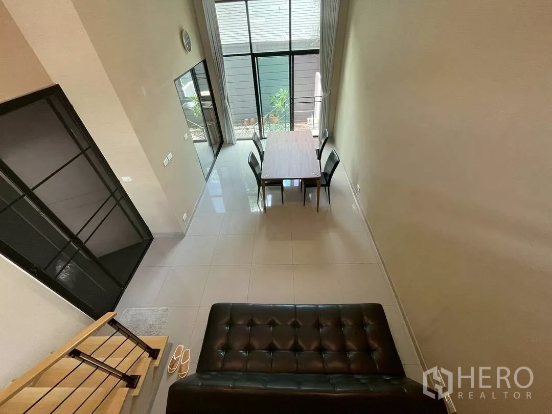 ทาวน์เฮาส์ ให้เช่าในSuan Luang, Bangkok - พื้นที่นั่งเล่นและทานอาหารเพดานสูง พร้อมกระจกบานใหญ่และพื้นกระเบื้องเงา ในทาวน์เฮาส์ย่านสวนหลวง.