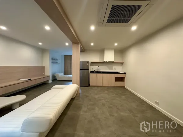 带办公室的家 出租在Phra Khanong, Bangkok - 开放式起居与办公区，带小厨房、筒灯与现代沙发。