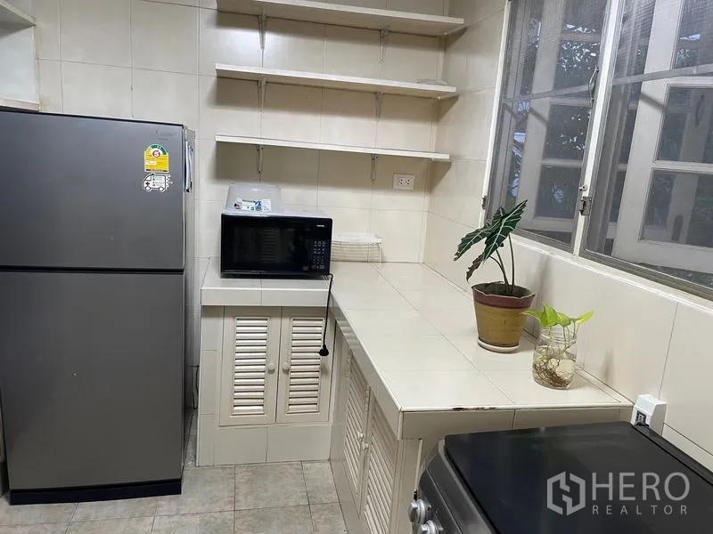 อพาร์ทเมนท์ ให้เช่าในWatthana, Bangkok - ห้องครัวปูกระเบื้องขนาดกะทัดรัด มีตู้เย็น ไมโครเวฟ ชั้นลอย และหน้าต่างบานใหญ่