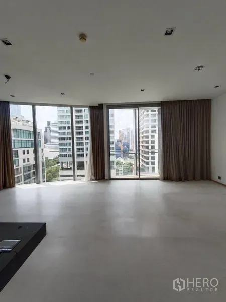 公寓 出租或出售在Bang Rak, Bangkok - 明亮客厅，落地窗连通阳台，俯瞰曼谷城市景观。