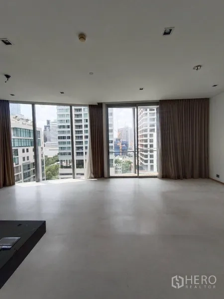 公寓 出租或出售在Bang Rak, Bangkok - 明亮客厅，落地窗连通阳台，俯瞰曼谷城市景观。