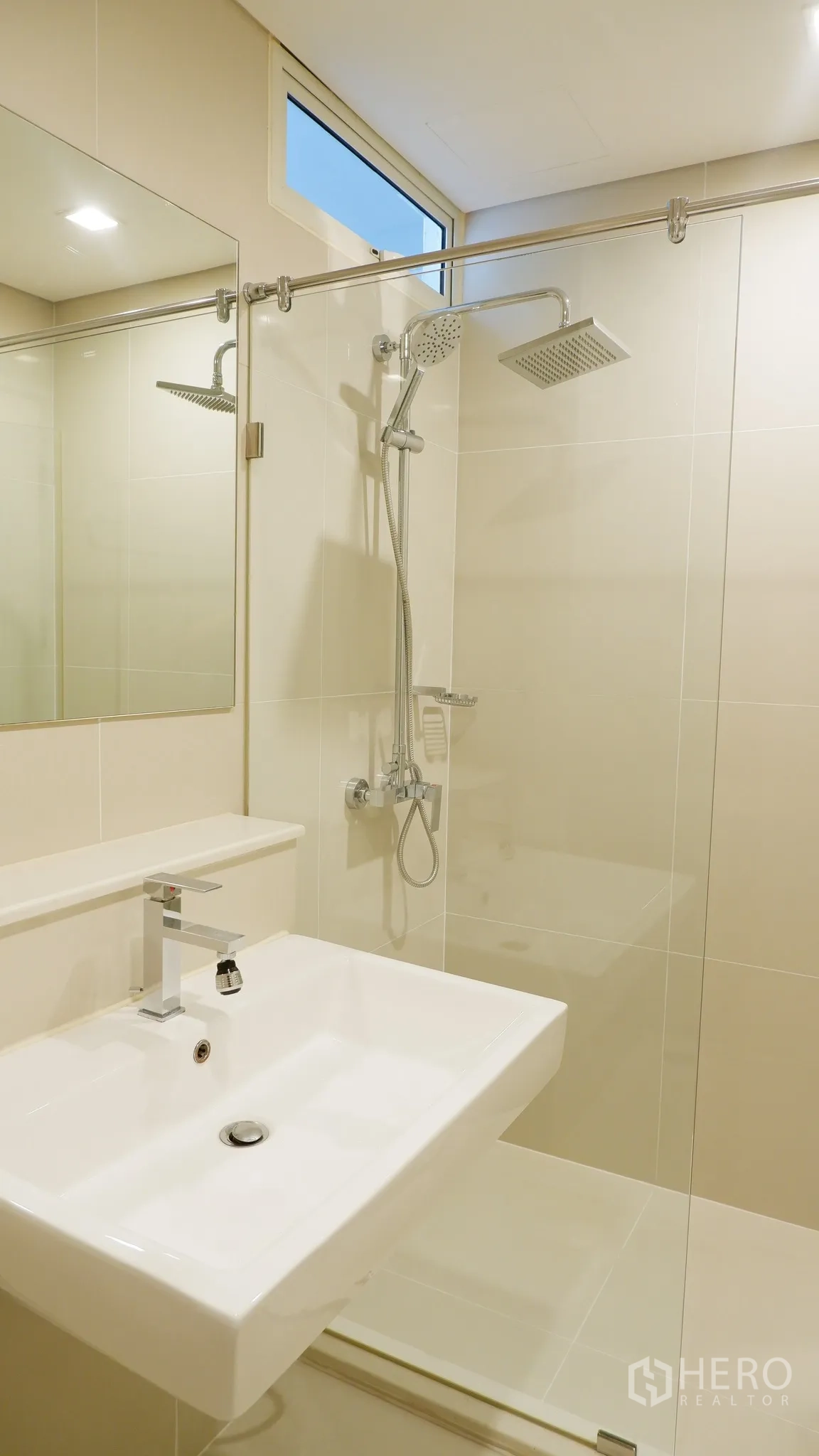 Condominium for rent in Watthana, Bangkok - Modern bathroom with glass-enclosed shower, rain showerhead, and rectangular basin.