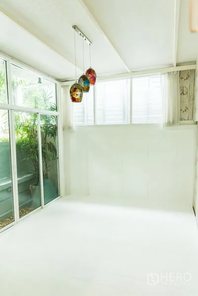 ทาวน์เฮาส์ ขายในWang Thonglang, Bangkok - ซันรูมสีขาวปิดกระจก โคมแขวนสีสันและมุมมองสวน