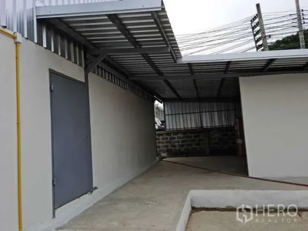货栈 出租在Bang Bua Thong, Nonthaburi - 仓库侧边带顶服务区，钢门与管线设施。