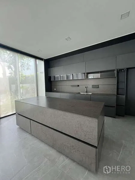 Detached House for sale in Bang Phli, Samut Prakan - Sleek dark modern kitchen with a large island and full-height cabinetry.