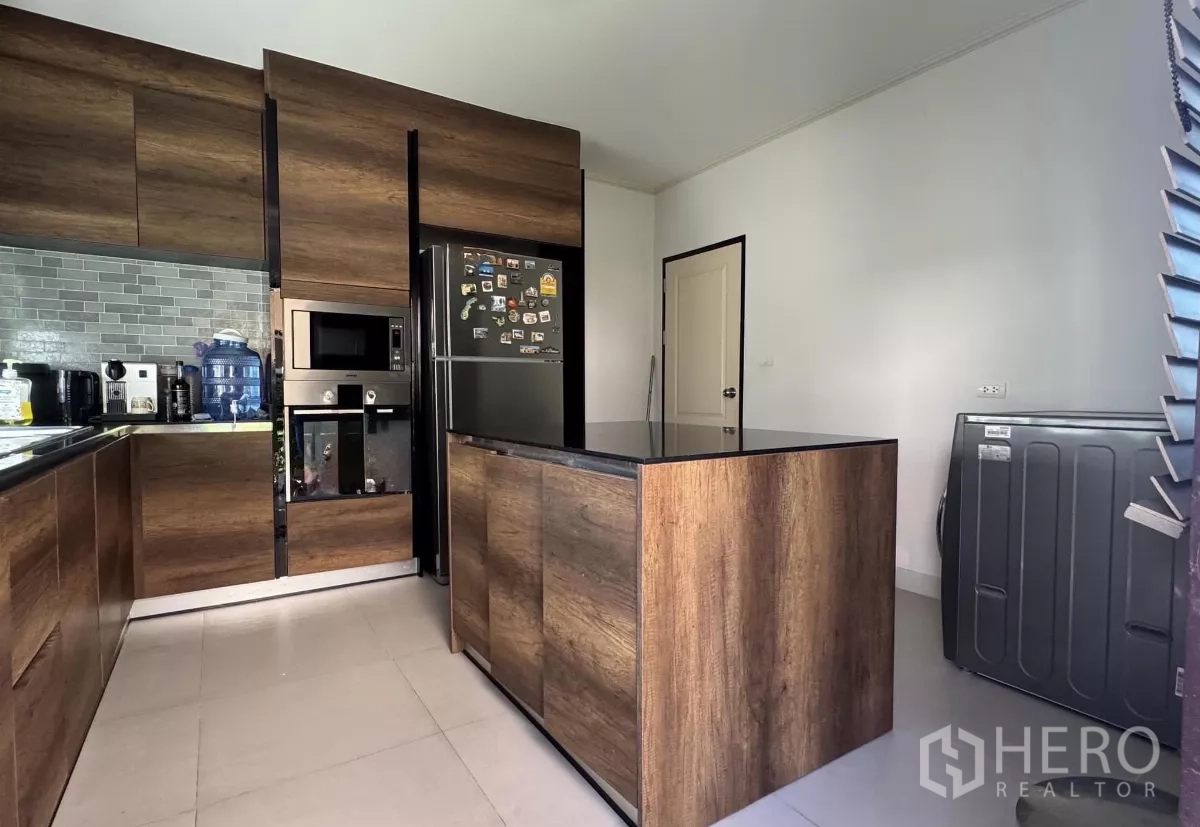 บ้าน ขายในLat Krabang, Bangkok - ครัวสไตล์โมเดิร์น เคาน์เตอร์ไม้รูปตัว U มีไอส์แลนด์ เครื่องใช้ไฟฟ้าบิวท์อิน