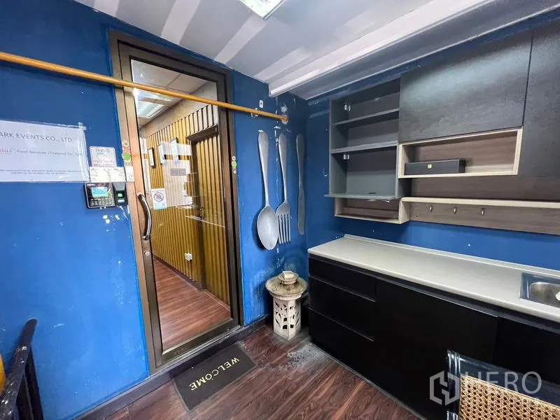 零售空间 出租或出售在Khlong Toei, Bangkok - 小型茶水间/服务室，带橱柜与水槽，旁有玻璃门。