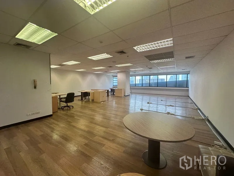 办公空间 出租在Bang Rak, Bangkok - 宽敞工作区，带办公桌、圆桌、大窗与荧光灯照明。