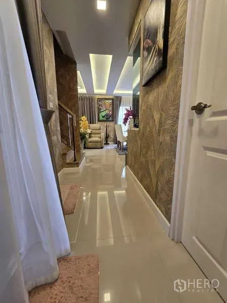 Detached House for rent in Thanyaburi, Pathum Thani - Bright hallway leading to the living and dining area with recessed ceiling lights and feature wallpaper.