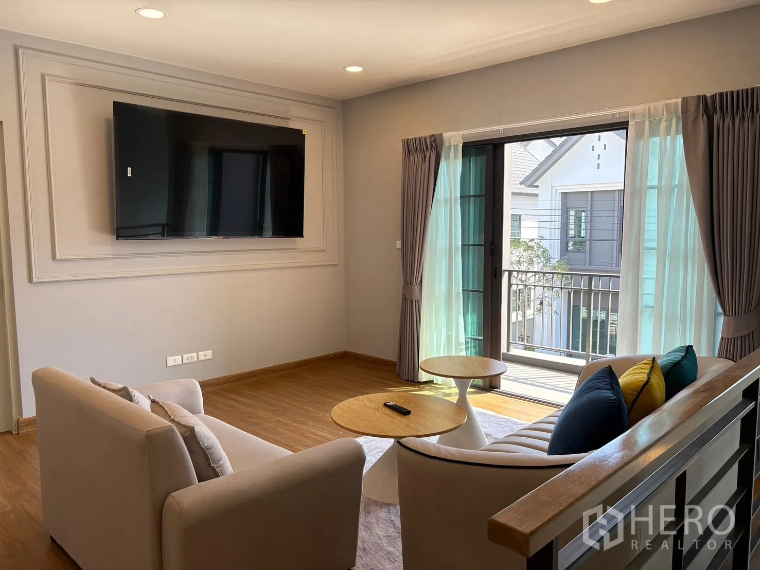 Detached House for rent in Bang Phli, Samut Prakan - Upstairs family room with sofa set, large TV and sliding glass doors opening to a balcony.