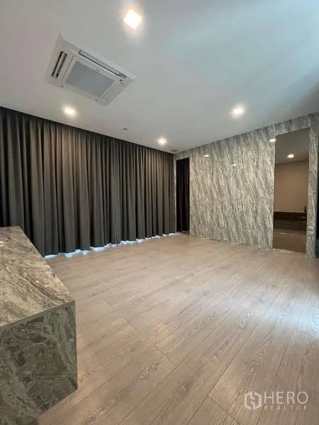Detached House for sale in Bang Phli, Samut Prakan - Bedroom with wood floors, blackout curtains and a marble feature wall.