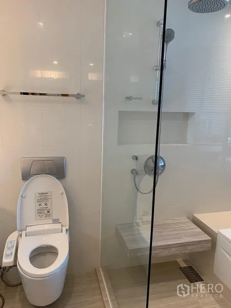 Condominium for rent in Watthana, Bangkok - Bathroom with glass-enclosed rain shower and smart bidet toilet.
