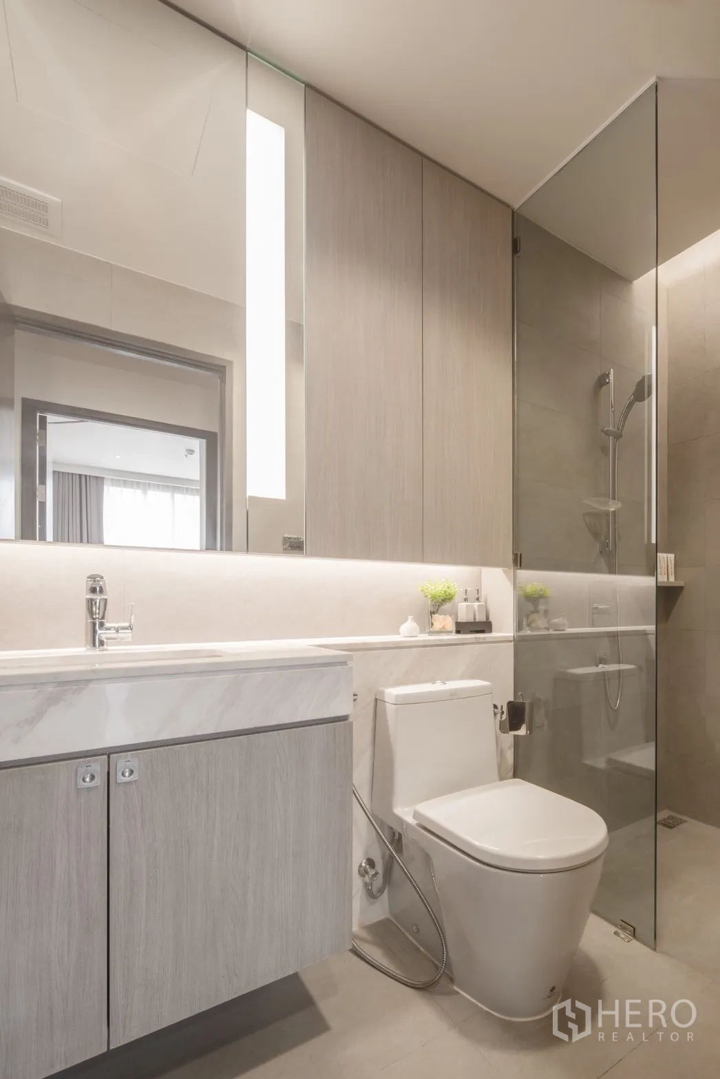 คอนโด for rent in Khlong Toei, Bangkok - ห้องน้ำสมัยใหม่ กระจกบานใหญ่ ตู้ล่างอ่างล้างหน้า และโถสุขภัณฑ์