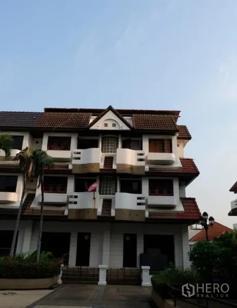 Townhouse for sale in Khlong Toei, Bangkok - Three-storey townhouse exterior in Phra Khanong with gabled roof, balconies and landscaped entry.