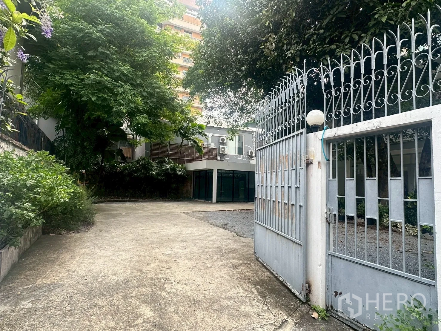 บ้าน ให้เช่าในWatthana, Bangkok - ประตูรั้วเหล็กเปิดเข้าสู่ทางรถยาวไปยังตัวบ้าน.