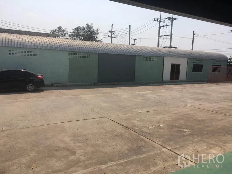 โรงงาน ขายในBang Lamung, Chon Buri - ลานคอนกรีตกว้างหน้าอาคารประกอบและกำแพงรั้ว