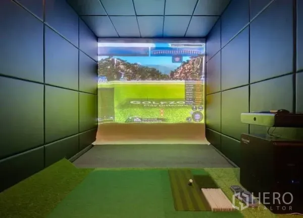 Condominium for rent in Watthana, Bangkok - Indoor golf simulator room with projector screen and putting mat in the condominium.