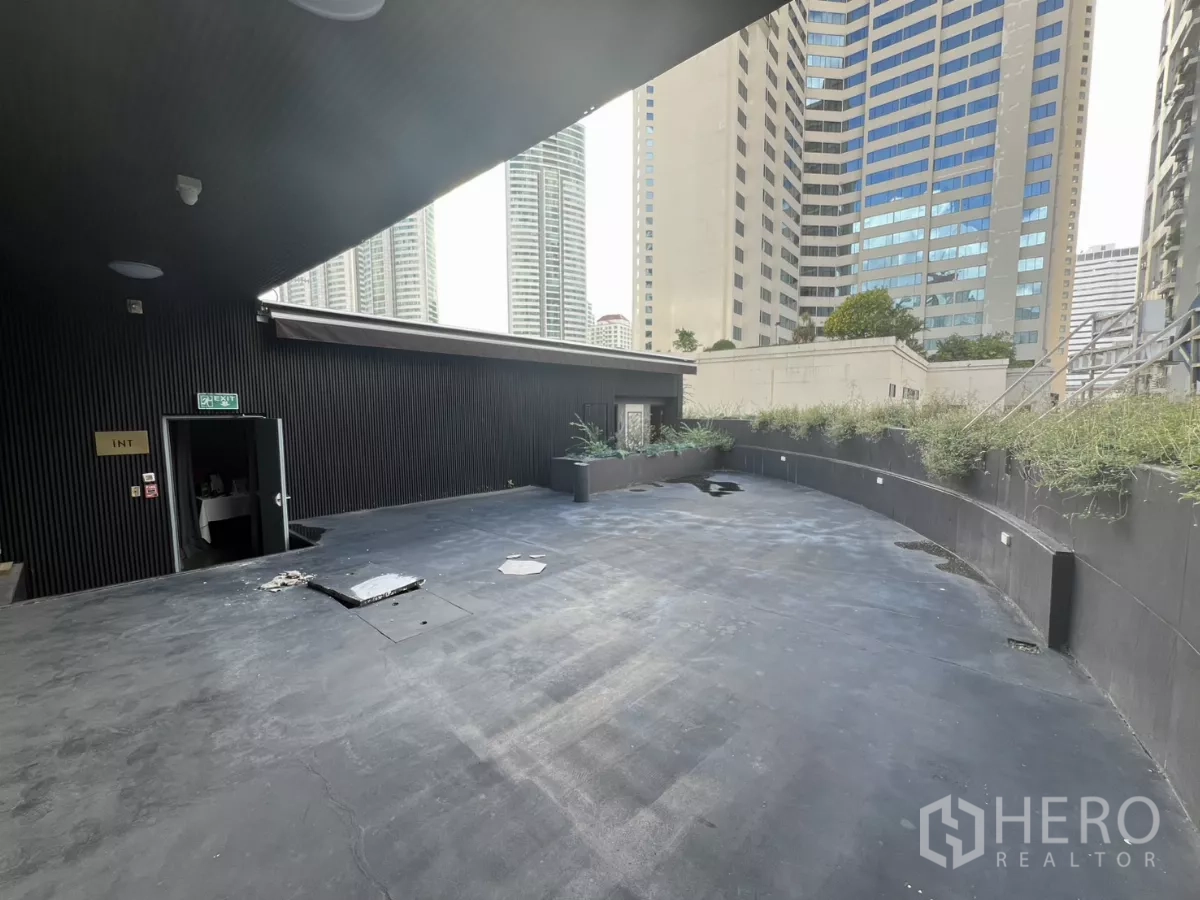 Retail Space for rent - Covered rooftop terrace with an exit door and greenery planters.