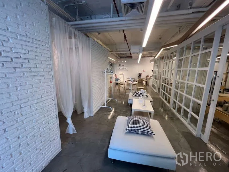พื้นที่ขายปลีก ให้เช่า - โถงร้านค้าแบบโอเพนแพลน ผนังกั้นกระจก ไฟเพดานสไตล์ลอฟต์ และมุมนั่งพัก