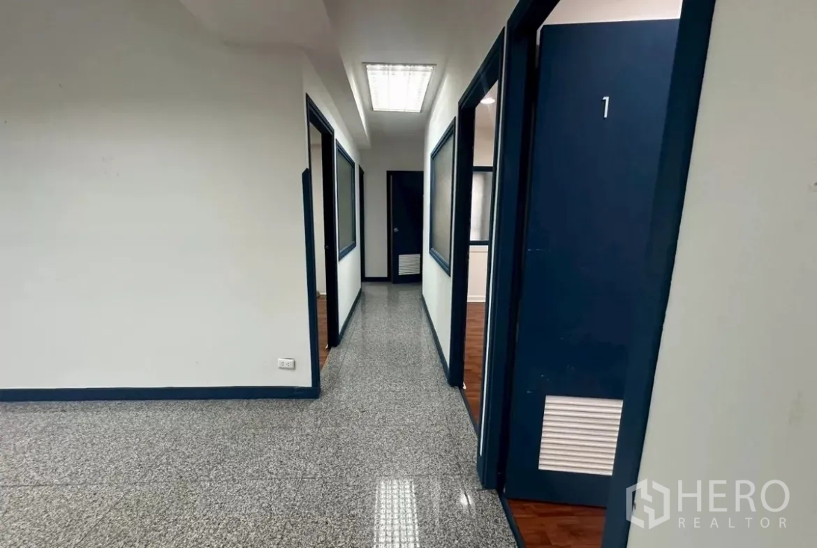 สำนักงาน ให้เช่าในKhlong Toei, Bangkok - ทางเดินพร้อมประตูหมายเลขสีน้ำเงินสู่ห้องกั้นหลายห้อง