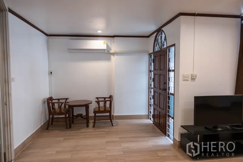 สำนักงานที่บ้าน ให้เช่าในKhlong Toei, Bangkok - พื้นที่รับแขกทางเข้า โต๊ะชุดเล็ก ชั้นวางทีวี และประตูไม้โค้ง