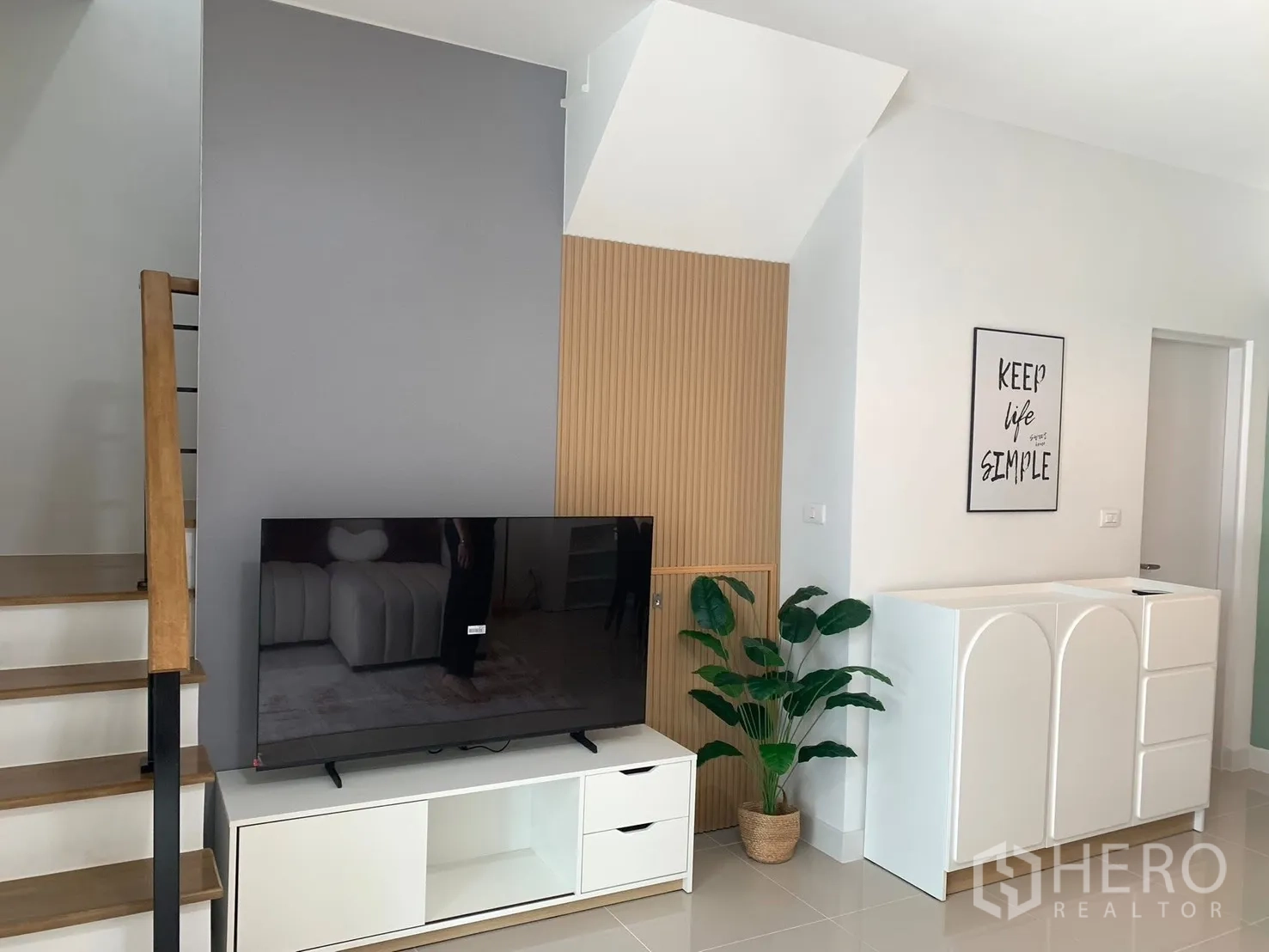 ทาวน์เฮาส์ for rent in Bang Phli, Samut Prakan - ผนังทีวีและบันไดตกแต่งมินิมอล ตู้เก็บของสีขาวและต้นไม้กระถาง