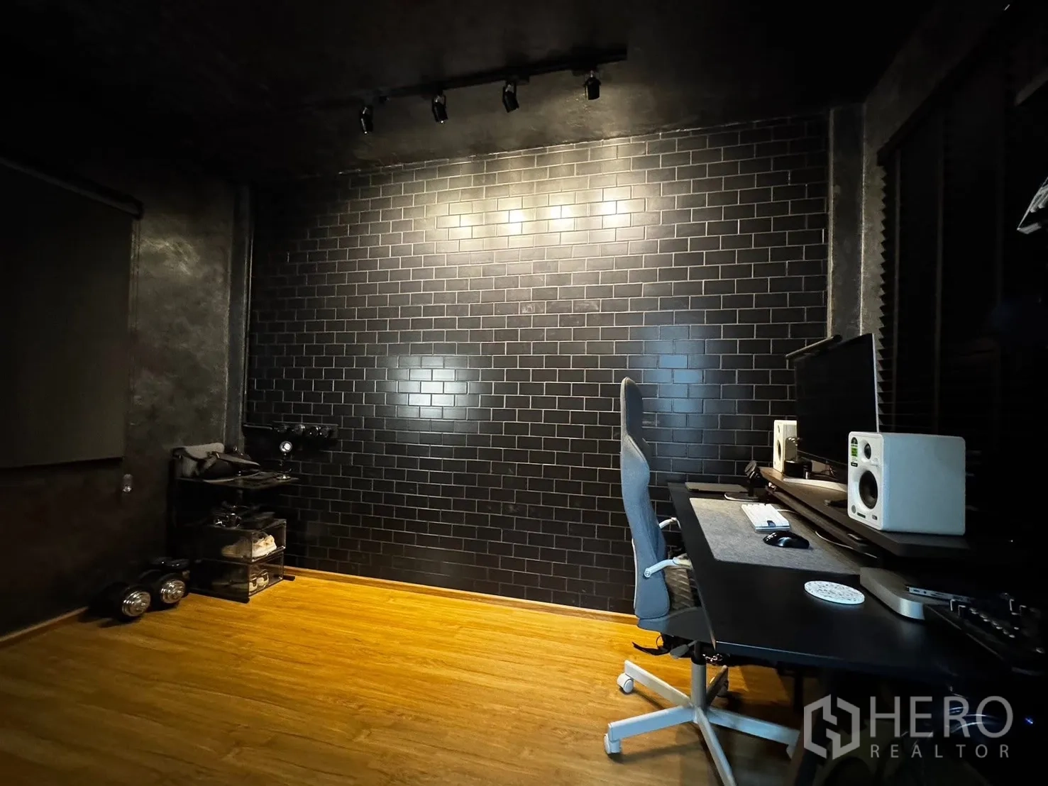 Townhouse for rent in Bang Phli, Samut Prakan - Dark studio workspace with black brick feature wall, desk, and monitors.