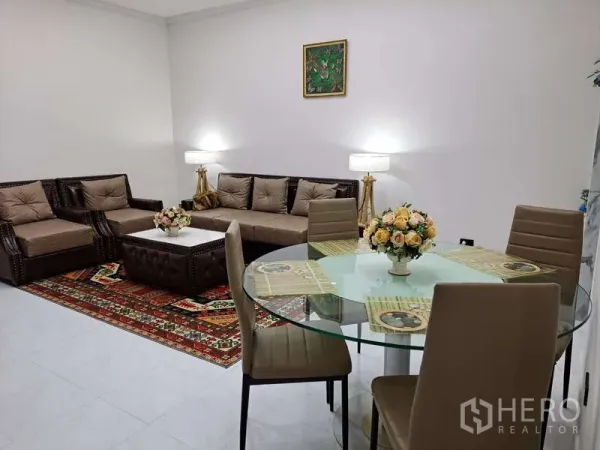 คอนโด ให้เช่าในKhlong Toei, Bangkok - ห้องนั่งเล่นและรับประทานอาหารแบบเปิด โต๊ะกระจก โซฟาหนัง พรมลาย และโคมไฟผนัง