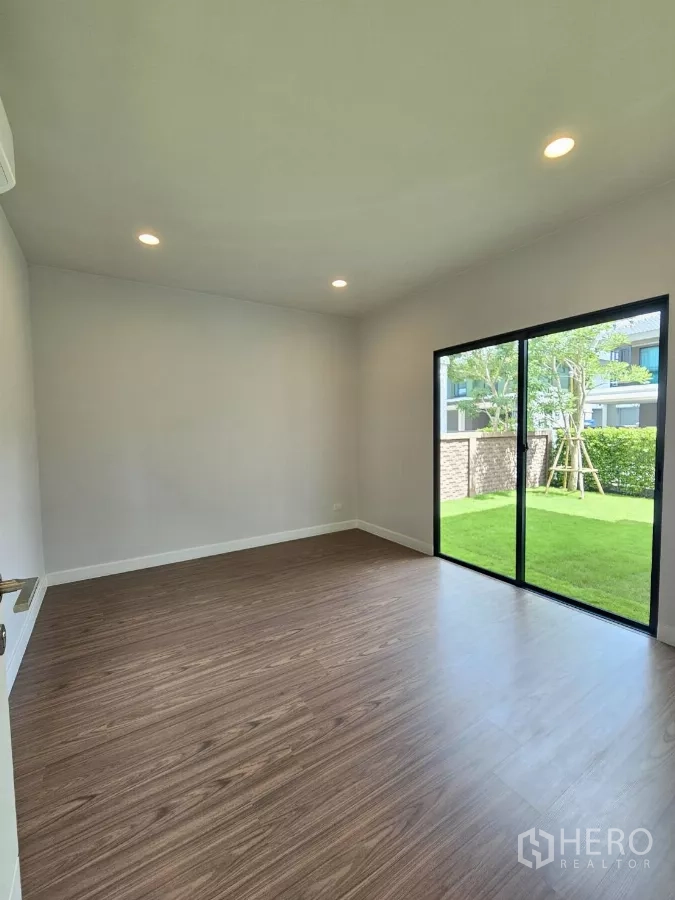 บ้าน ขายในLam Luk Ka, Pathum Thani - ห้องนอนชั้นล่างพื้นลามิเนต ไสลด์ประตูออกสู่สวน