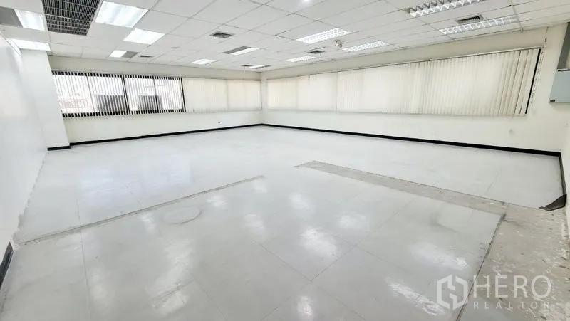 Office Space for rent in Watthana, Bangkok - Open office shell with a raised-floor cutout and windows on two sides.