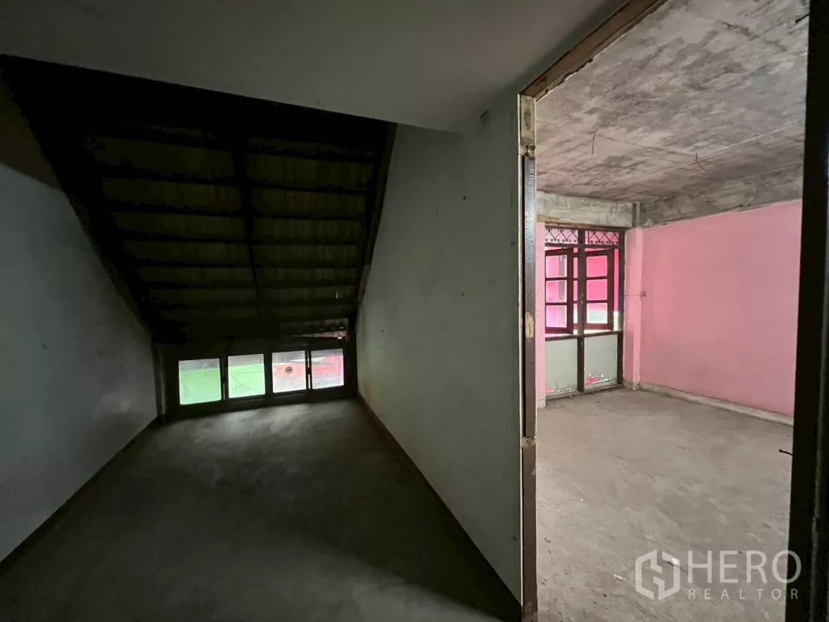 店屋 出租在Watthana, Bangkok - 走廊可见斜顶空间与带窗的粉色房间并列。