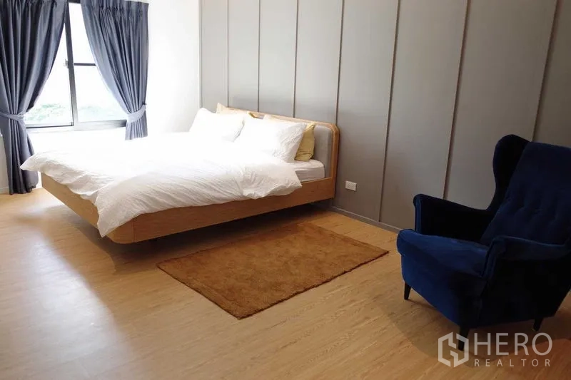 คอนโด ให้เช่าในWatthana, Bangkok - ห้องนอนหลัก เตียงคิง พื้นไม้ ผนังตกแต่ง และเก้าอี้กำมะหยี่สีน้ำเงิน