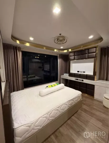 Condominium for rent in Chatuchak, Bangkok - Bedroom with large picture window, blackout curtains, and integrated under-bed storage.