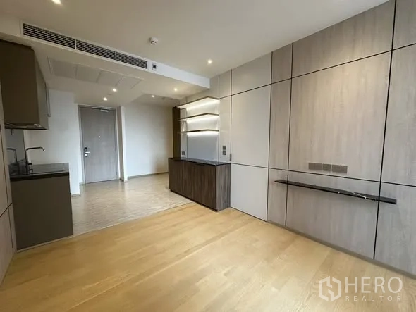 คอนโด for sale in Din Daeng, Bangkok - พื้นที่นั่งเล่นผนังตกแต่ง แผ่นชั้นวางทีวีลอยตัว และครัวขนาดกะทัดรัดตรงข้ามประตูเข้า