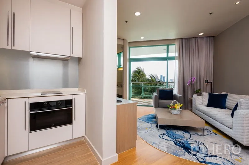 คอนโด ให้เช่าในBang Kho Laem, Bangkok - ครัวเล็กข้างห้องนั่งเล่นสว่างไสวด้วยหน้าต่างสูงจรดเพดาน มองเห็นเมืองและต้นปาล์ม