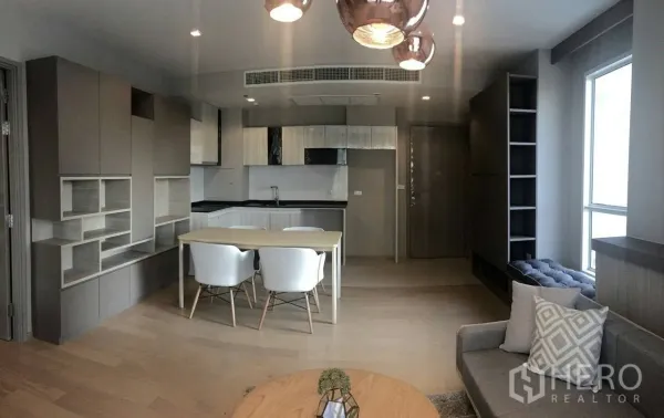 คอนโด ให้เช่าในWatthana, Bangkok - เลย์เอาต์เปิดโล่งเห็นครัว พื้นที่ทานข้าว และนั่งเล่น พร้อมโคมไฟแขวนและม้านั่งริมหน้าต่าง