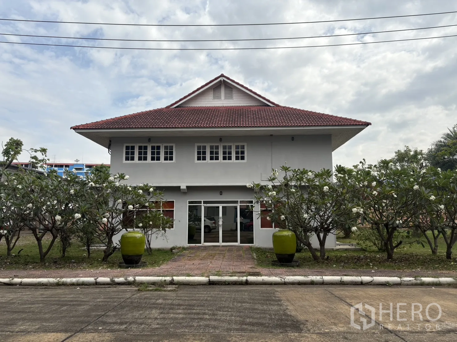 工厂 出租在Phra Pradaeng, Samut Prakan - 两层次办公楼，红色瓦顶与绿化景观。