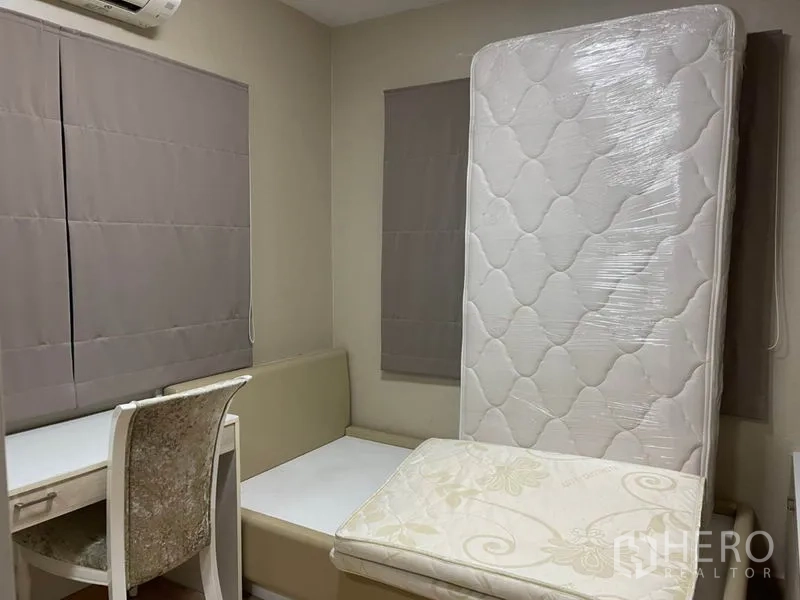 Detached House for sale in Khlong Toei, Bangkok - Compact bedroom with study desk, daybed platform and mattresses.