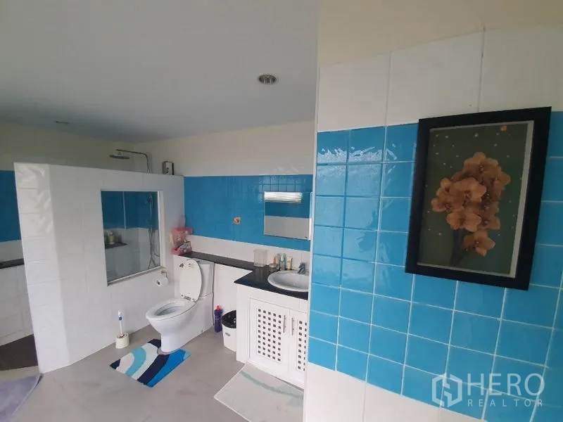 Townhouse for rent in Phaya Thai, Bangkok - Large bathroom featuring blue-and-white tiles, vanity sink, toilet and a separated shower area.