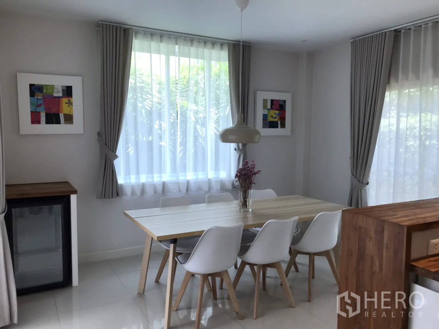 独立式住宅 出租或出售在Saphan Sung, Bangkok - 明亮餐区，六人餐桌、吊灯与落地窗帘。