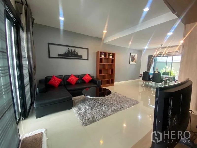 Home Office for rent or sale in Bang Phli, Samut Prakan - Bright living room with black sectional sofa, round coffee table and sliding doors.