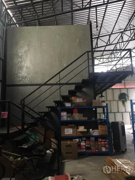 Warehouse for rent in Bang Kapi, Bangkok - Steel staircase to mezzanine office with shelving and storage under a high roof.